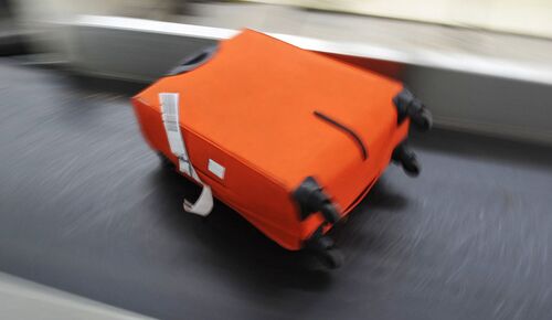 Orange baggage on a baggage conveyor belt